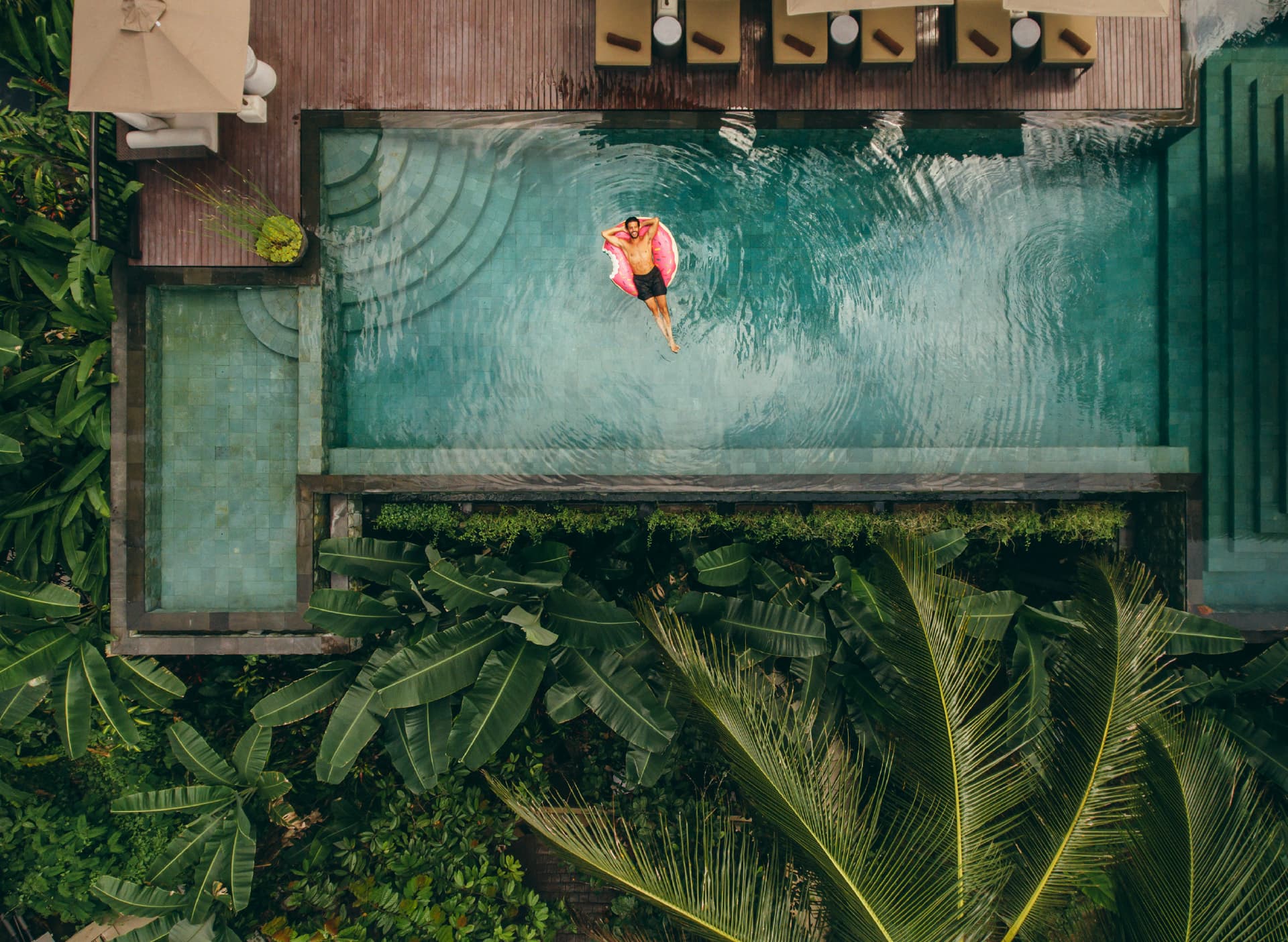 A guest floating on a pool at a Seven Cities residence, seen from above